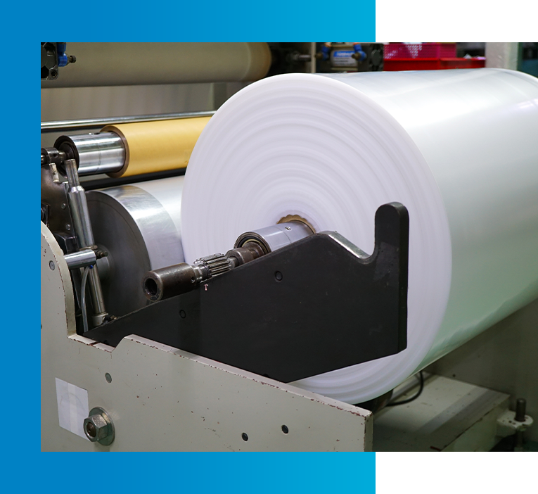 Large white paper roll in industrial printing machine.
